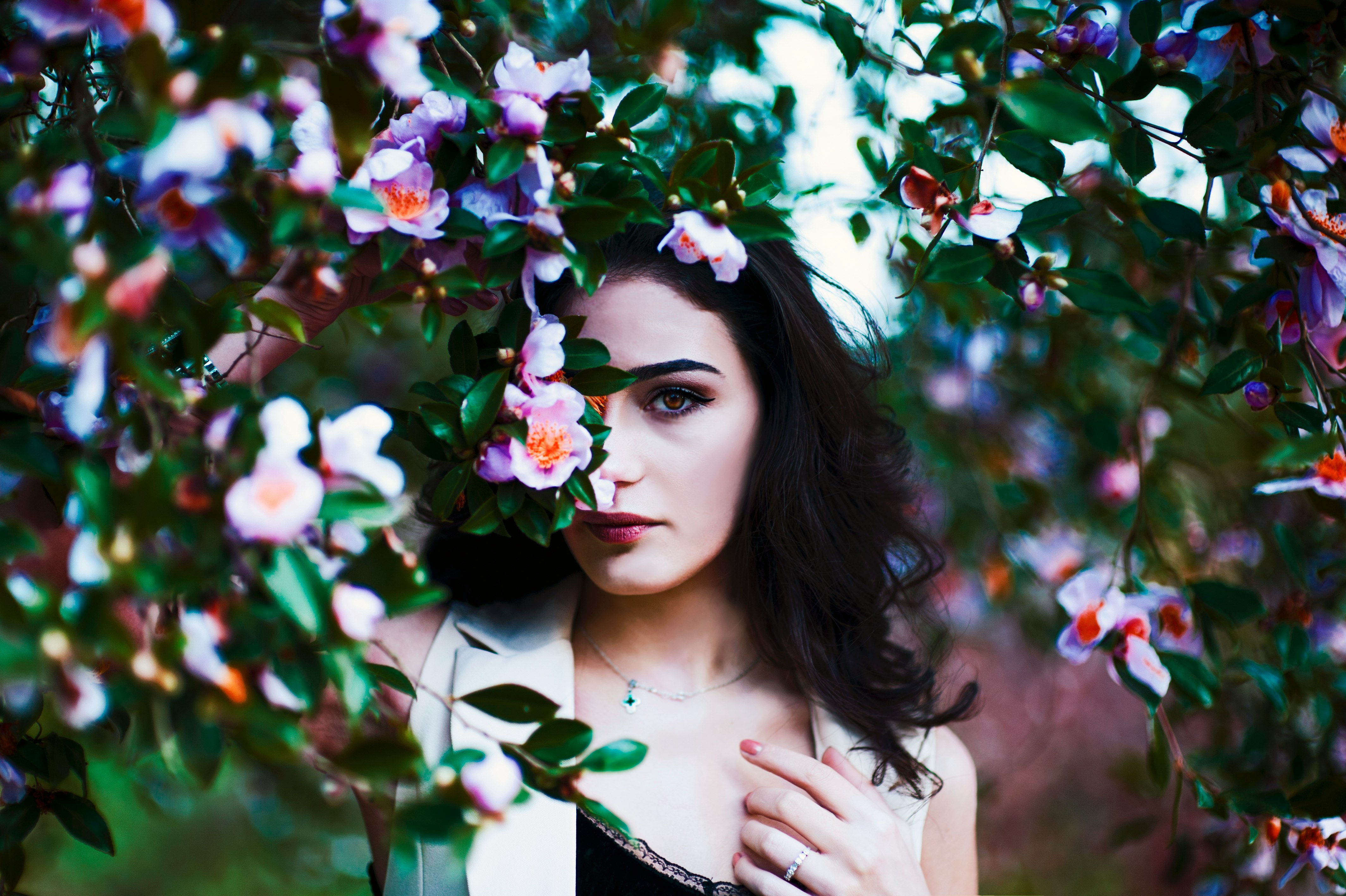 selective focus of woman hiding on flowers during daytime